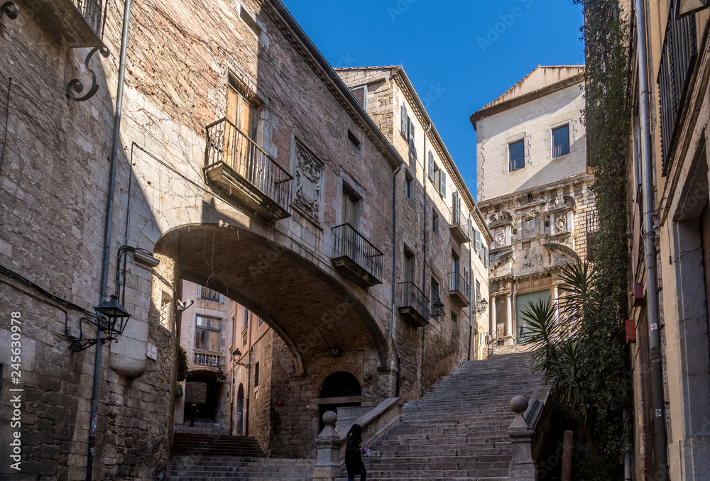View of medieval buildings, tower and street in Girona Catalonia, Spain with blue sky, popular tourist town one hour from Barcelona