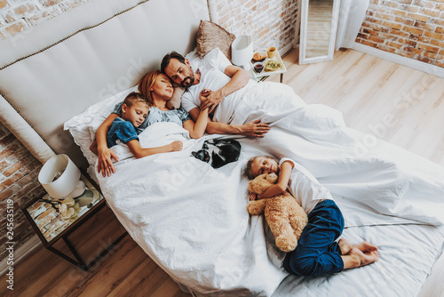 Top view of family sleeping together in bed photo