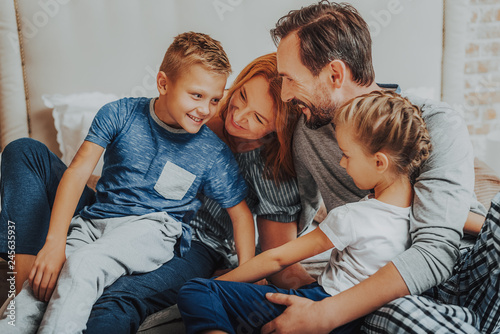 Happy parents and two kids embracing together
