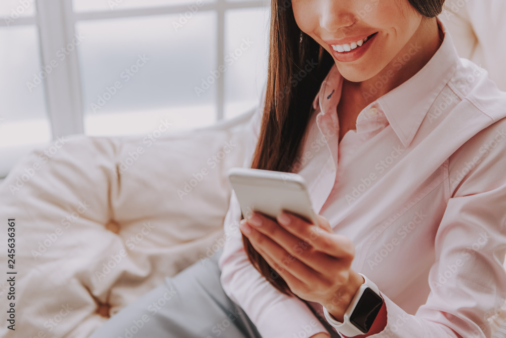 Smiling young asian woman looking at mobile phone Smiling young asian woman looking at mobile phone