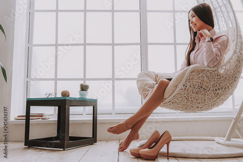 Smiling young woman resting in cozy chair photo