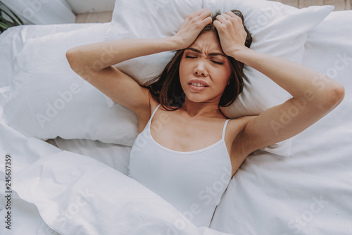 Frustrating young girl lying in bed in morning