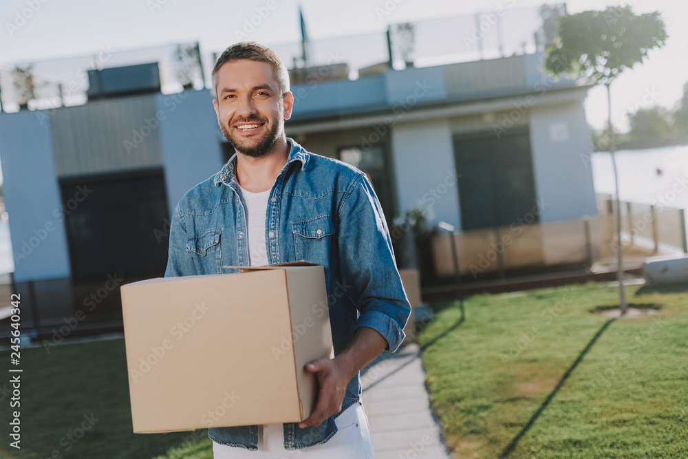 Waist up of a pleasant man holding a paper box