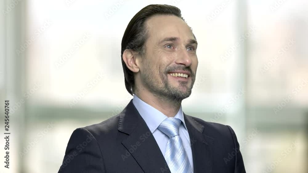 Smiling caucasian businessman remembered something. Face of joyful daydreaming entrepreneur looking upwards on blurred background. Smiling caucasian businessman remembered something. Face of joyful daydreaming entrepreneur looking upwards on blurred background.