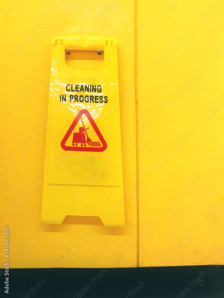 Warning signs for cleaning on yellow wall. Warning signs for cleaning on yellow wall.