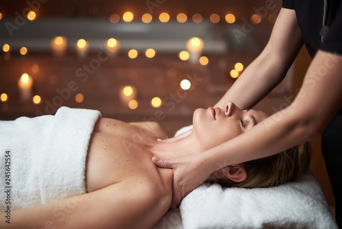 Young lady have massage of neck in spa salon