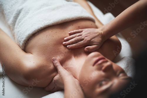 Young lady have low neck massage in spa salon