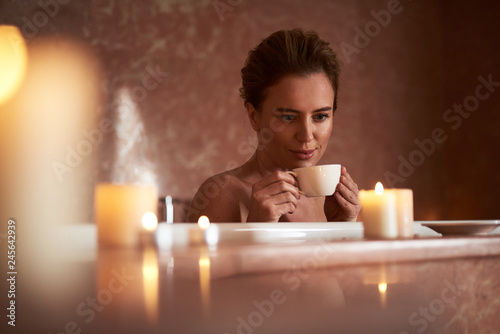 Close up of young lady drink tea in relaxed bath