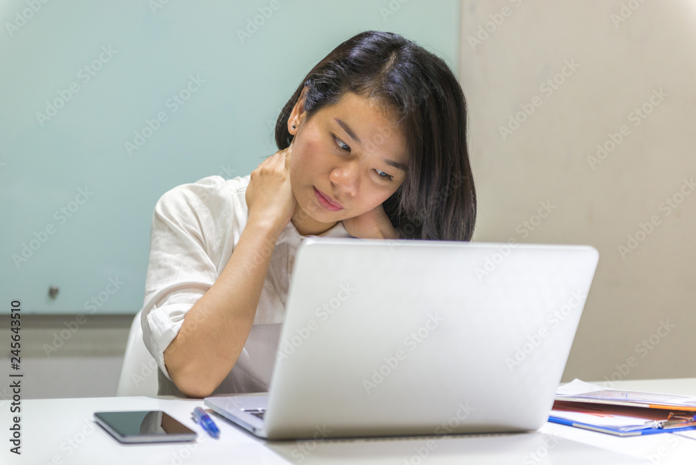 Young Asian woman putting arms behind her head taking a break from work Young Asian woman putting arms behind her head taking a break from work