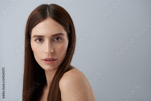 Beautiful girl with natural makeup standing against light blue background