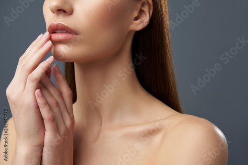 Young woman with beautiful full lips posing on blue-gray background