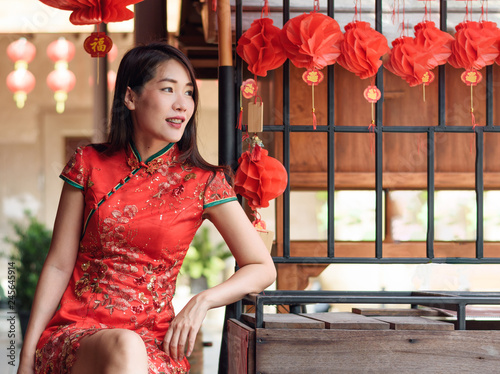 Fotografie asian woman wearing red traditional dress in chinese new year festival backgroun