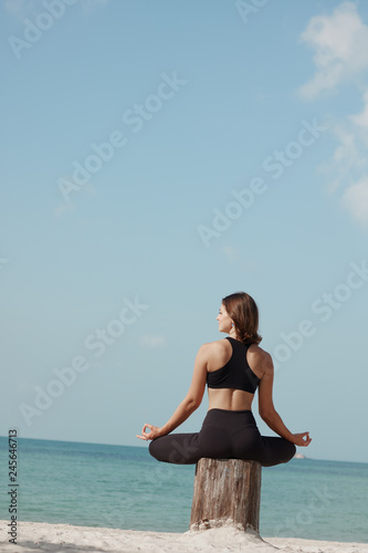 Young woman doing asanas on the beach