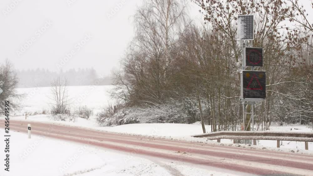 Winter Blizzard snow road with electronic sign. Dangerous road curve. Slow motion Winter Blizzard snow road with electronic sign. Dangerous road curve. Slow motion