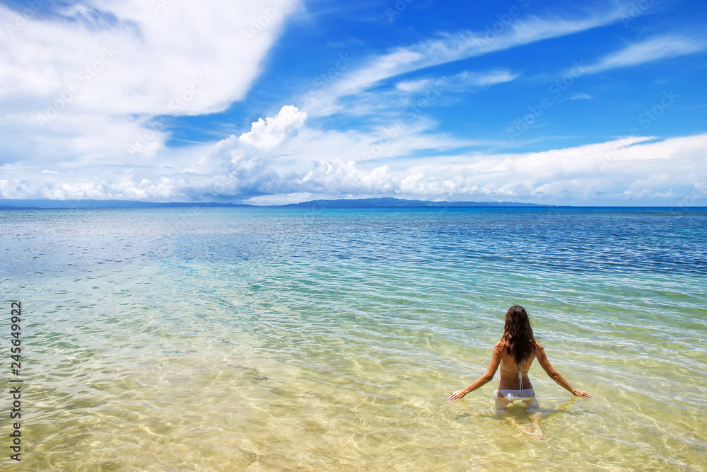 Young woman sitting in clear water on Taveuni Island, Fiji