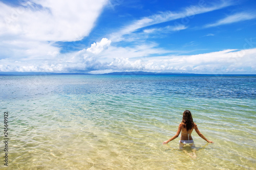 Young woman sitting in clear water on Taveuni Island, Fiji