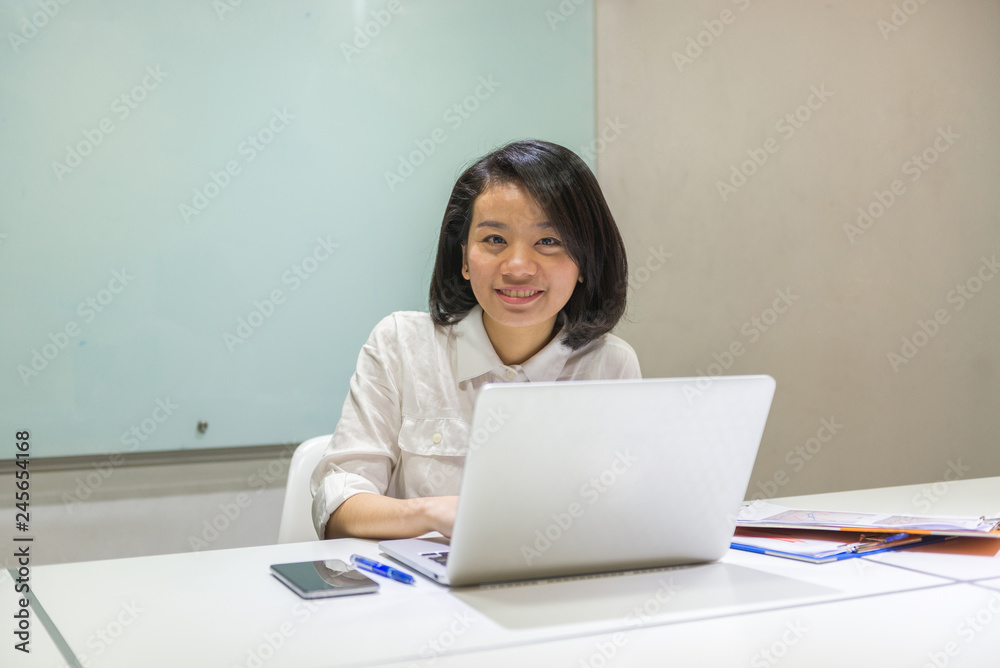 Smiling Asian office woman working in the business office Smiling Asian office woman working in the business office