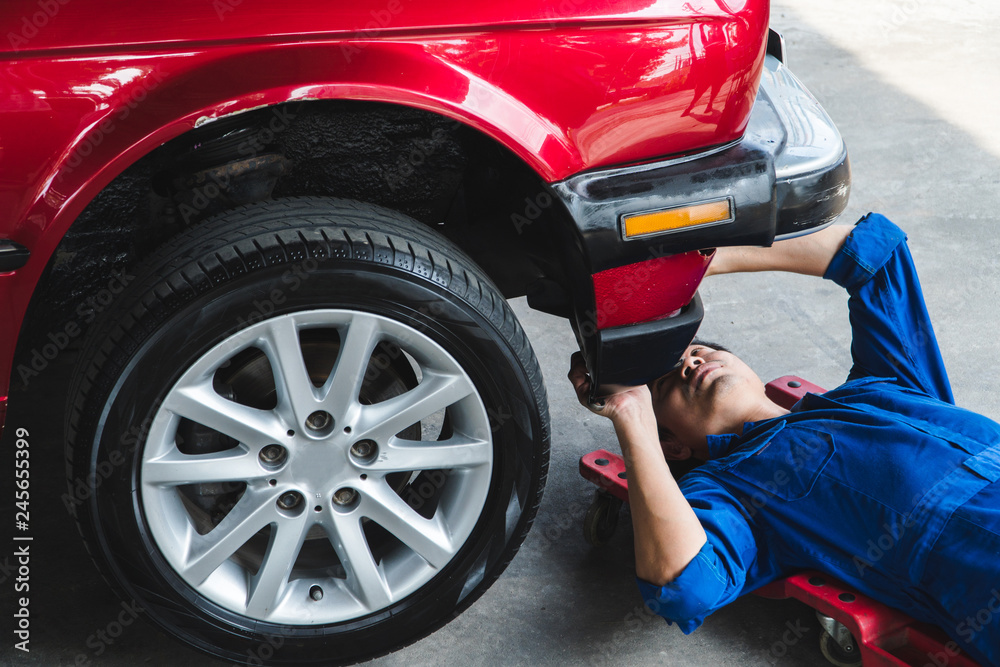 Mechanic engineer use wrench to repair the car in the garage - Image Mechanic engineer use wrench to repair the car in the garage - Image