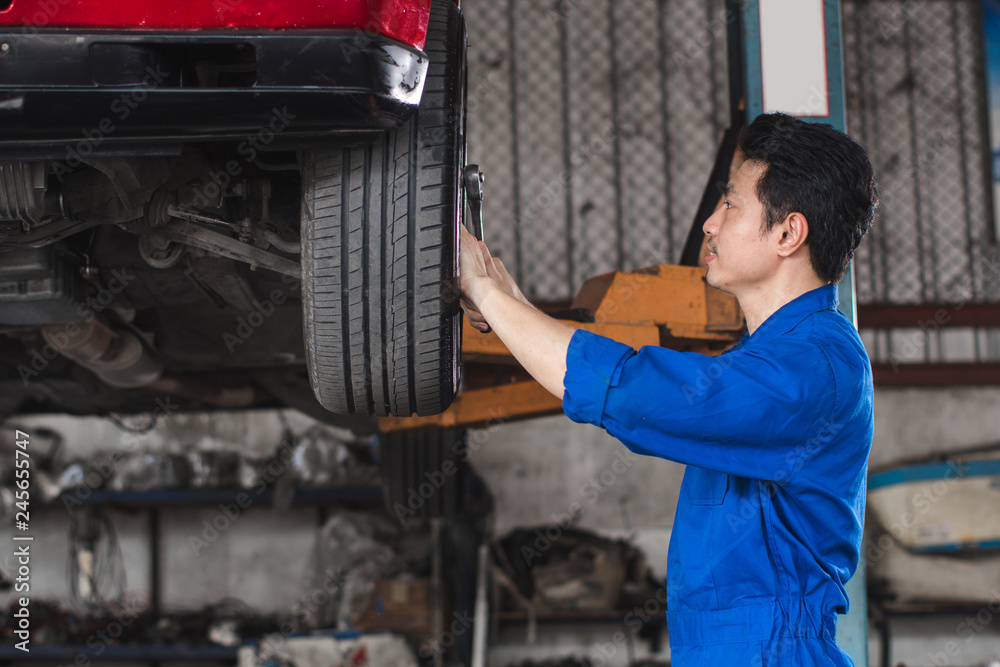 Mechanic checking the wheels of car And is about to change tires - Image Mechanic checking the wheels of car And is about to change tires - Image
