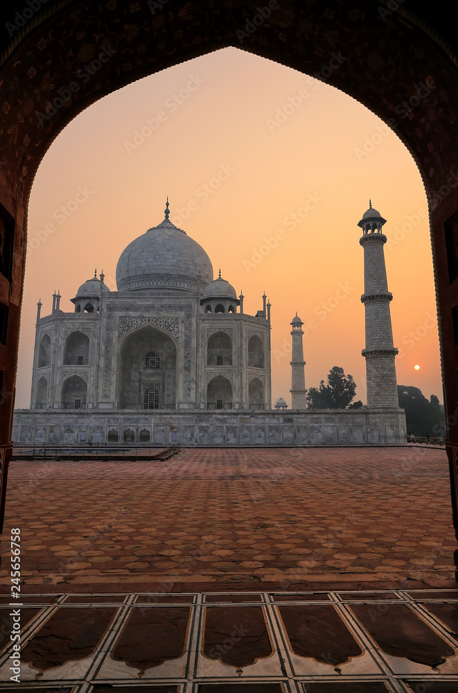 Fototapeta premium Taj Mahal at sunrise framed with the arch of the mosque, Agra, Uttar Pradesh, India