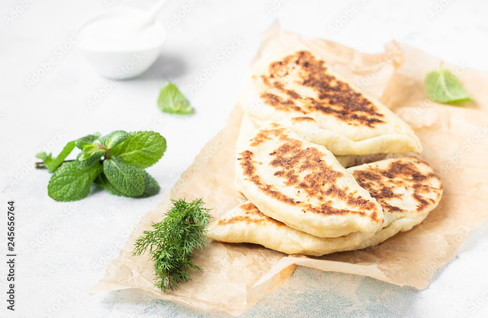 Frying pan baked flat bread with fresh herbs and yogurt dressing. Khychiny or qutab - traditional caucasian or Azerbaijani flatbread. Frying pan baked flat bread with fresh herbs and yogurt dressing. Khychiny or qutab - traditional caucasian or Azerbaijani flatbread.