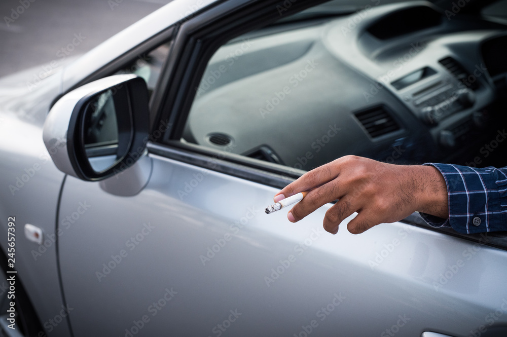 Close up male hand smoking in car Close up male hand smoking in car