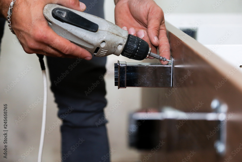 Worker use drill to repair furniture