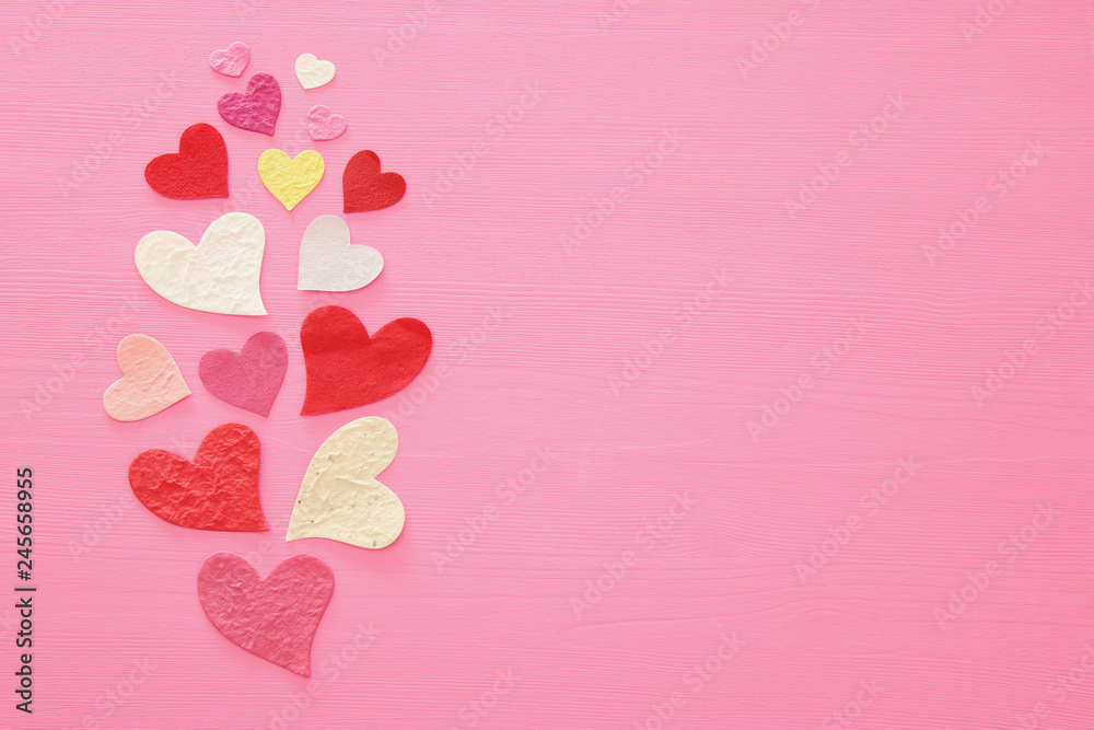 Valentine's day concept. Paper hearts over wooden pink background. Flat lay.