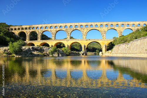 Aqueduct Pont du Gard reflected in Gardon River, southern France