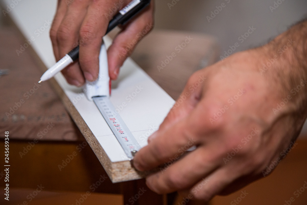 Repairman rules with ruler on furniture