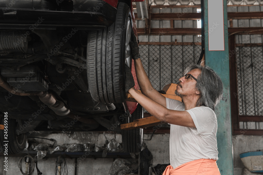 Mechanic checking the wheels of car And is about to change tires - Image