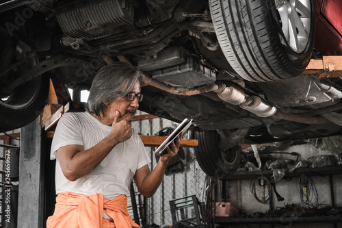 mechanic engineer repair the car and checklist fix item with tablet in the garage - Image