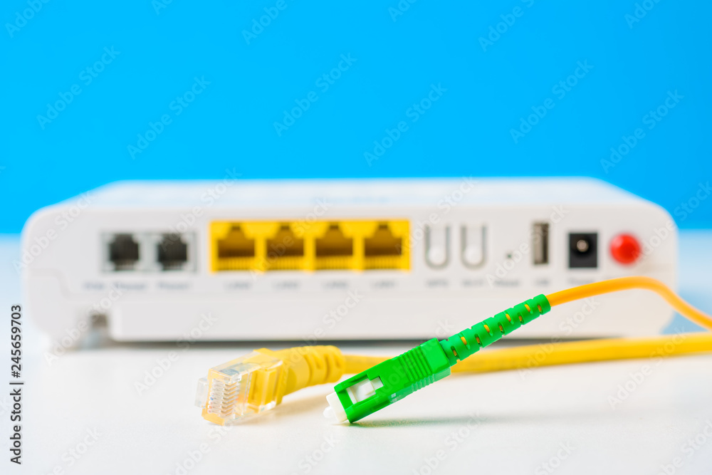 Fiber optical and network cables with internet wireless router on a blue  background foto de Stock | Adobe Stock