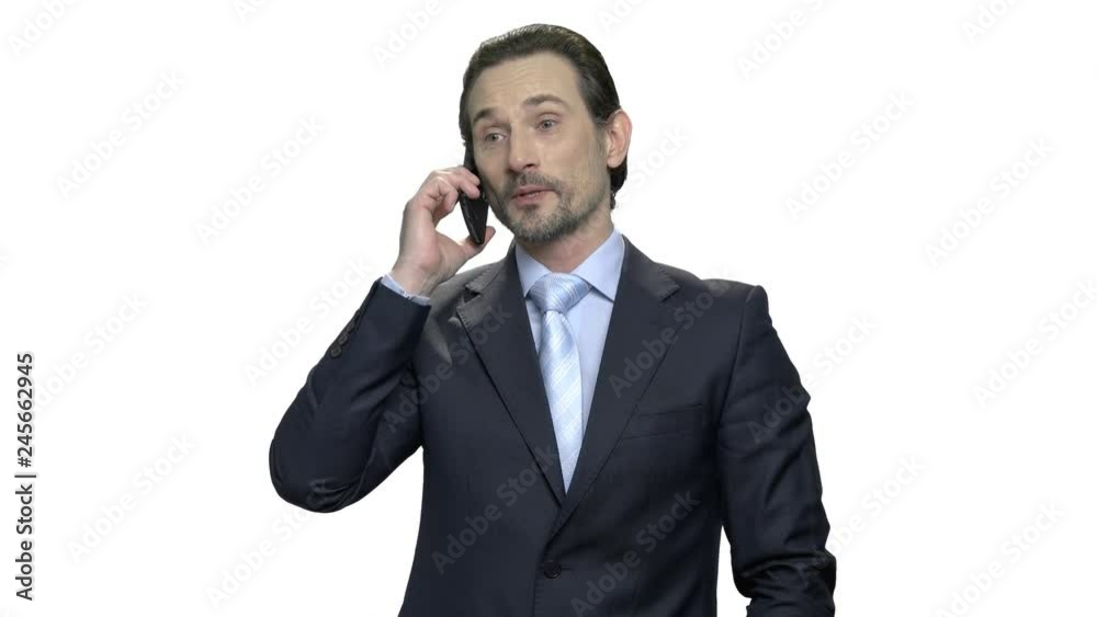 Good-looking mature businessman talking on cell phone. Prosperous confident businessman dressed in fashionable suit. Isolated on white background. Good-looking mature businessman talking on cell phone. Prosperous confident businessman dressed in fashionable suit. Isolated on white background.