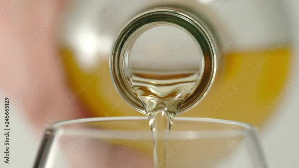 SLOW MOTION: Pouring whiskey from a bottle in a glass - Macro SLOW MOTION: Pouring whiskey from a bottle in a glass - Macro
