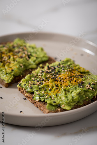 Avocado Kurkuma Sesam Vollkorn Sonnenblumenkern Brot als Snack oder Frühstück auf Marmor Hintergrund