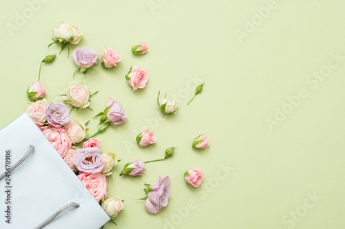 Fresh roses delivery. Flower congratulation concept. Copy space on green background.