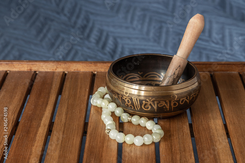 Fototapeta Naklejka Na Ścianę i Meble -  Tibetan singing bowl and jade beads on a wooden stand