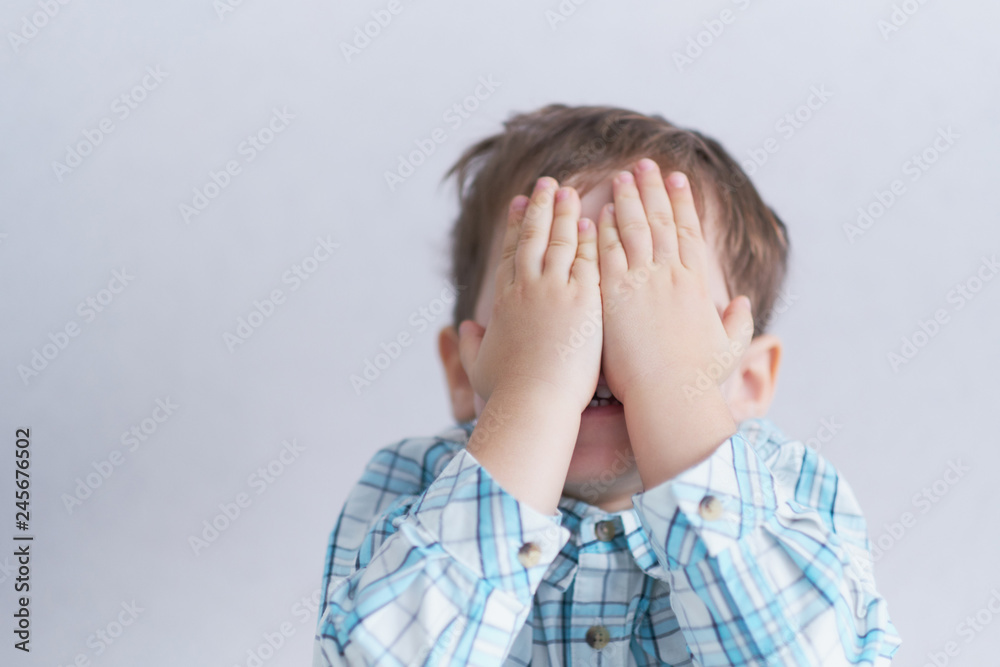 funny boy three years old hid his face in his hands. childhood fears. funny boy three years old hid his face in his hands. childhood fears.