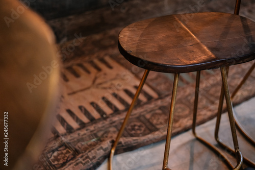 Rustic wood and bronze metal bar stools. Close up details. Coffee shop, home loft interior design, minimalism concept