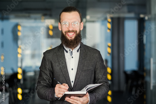 business coach and career training. smiling man holding notebook and pen.