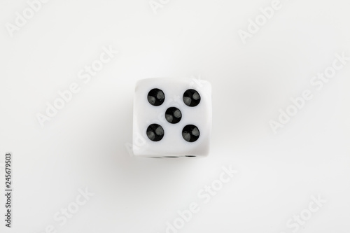 Single white with black dots dice on a white background, showing number five