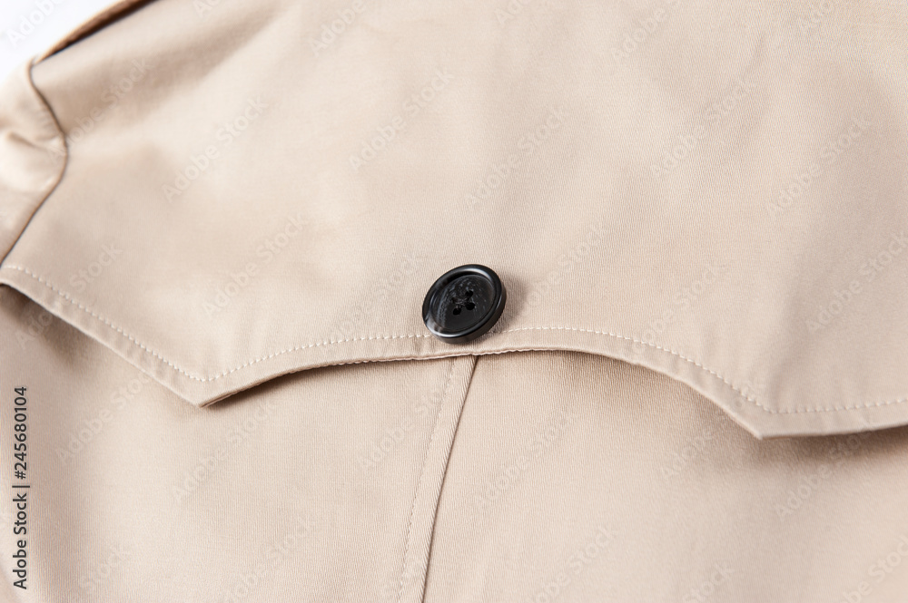 Beige trench coat button close-up Beige trench coat button close-up