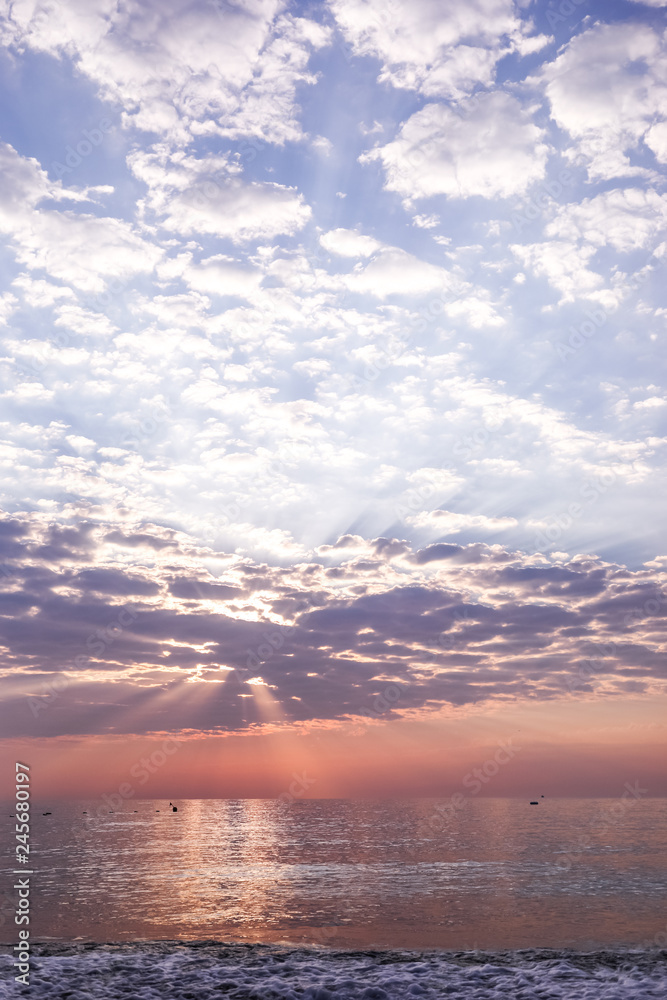 View of seascape with beautiful sky with clouds and sunbeams on sunrise.