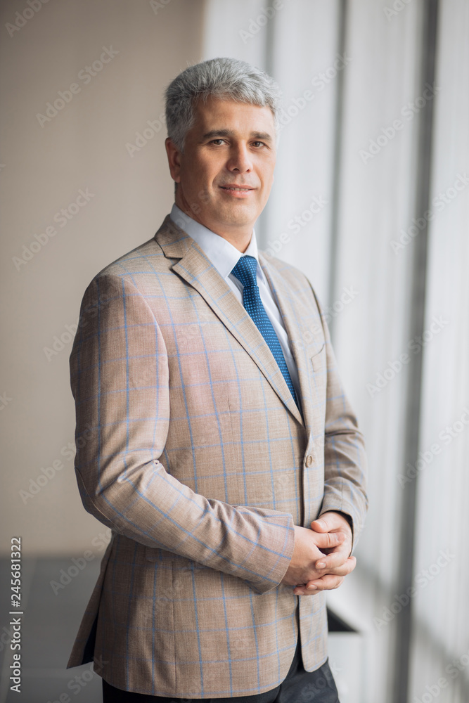 awesome good looking senior man is posing to the camera at work place. smart old office worker . close up portrait. formal style in outfit awesome good looking senior man is posing to the camera at work place. smart old office worker . close up portrait. formal style in outfit