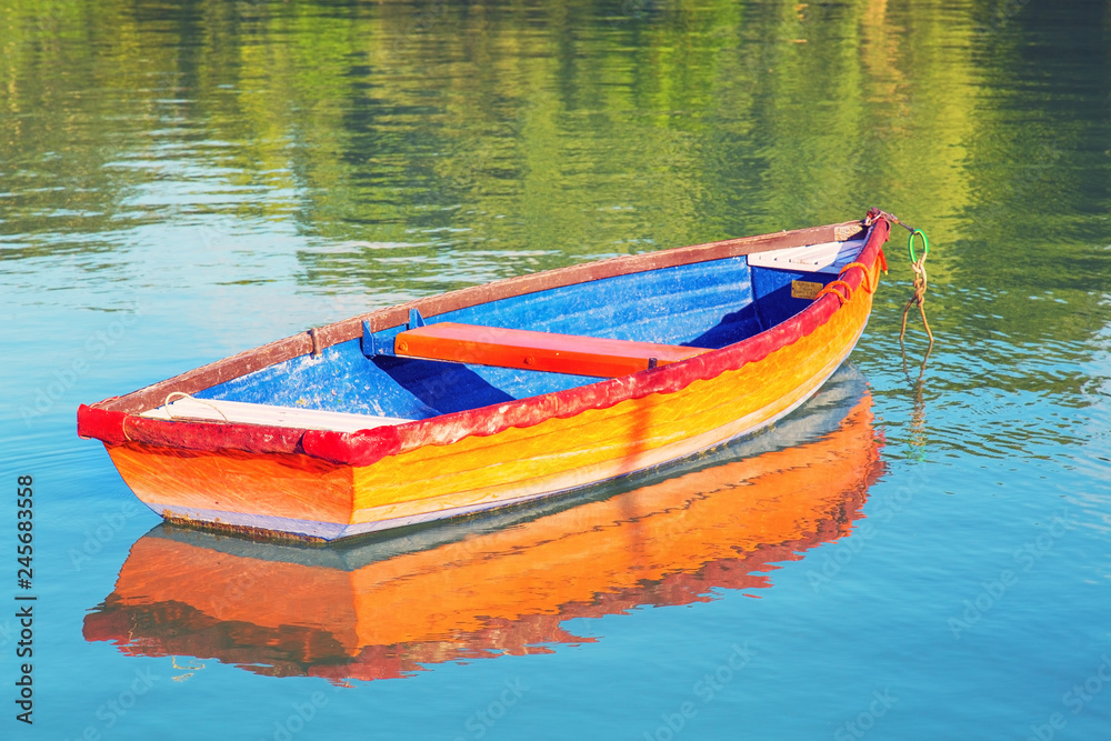 Colorful rowboat floating on clear water