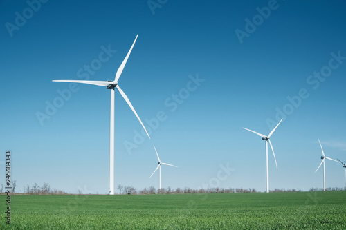 Wind power station on field. Technology and inovation. Green energy composition. Wind turbines. Industrial landscape
