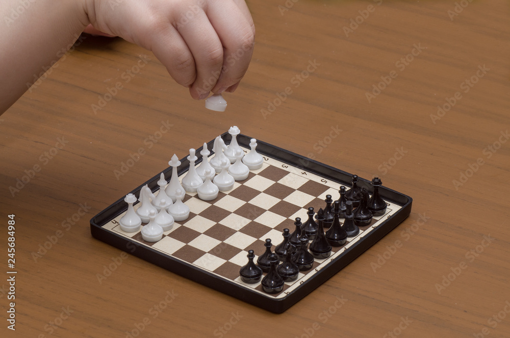 Playing chess, the child makes the first move. Playing chess, the child makes the first move.