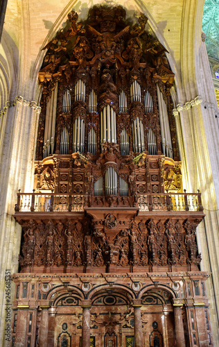 Heavily decorated and carved pipe organ inside the cathedral of Seville, Spain
