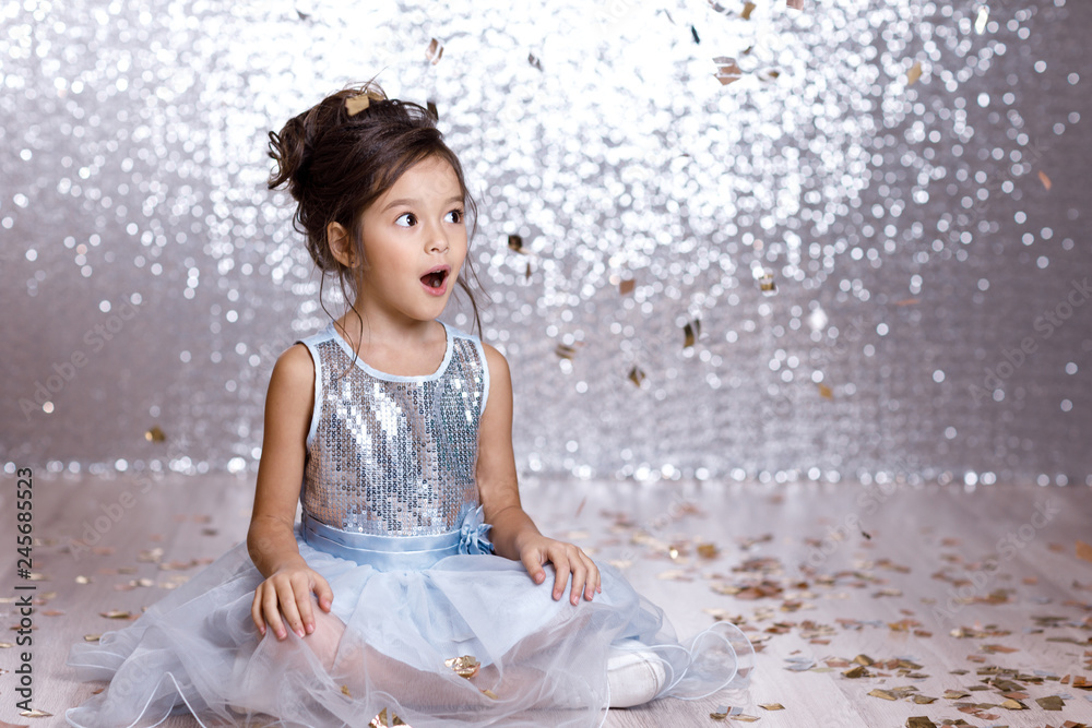 little girl in blue dress sitting on the floor with confetti Stock ...